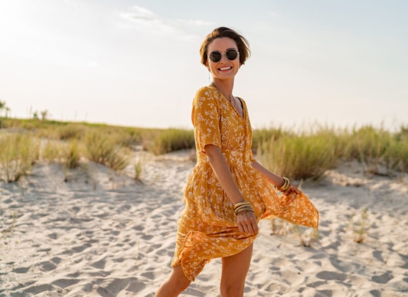prikaz devojke u maksi haljini sa naočarama na glavi na plaži